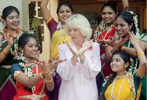  ?? AP ?? Camilla attempts a hand gesture used in Indian classical dance as she poses with students during a visit to the Asha Sadan children’s home in Mumbai on Saturday. —