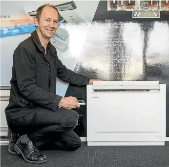  ??  ?? Enviro Master co-owner Grant Wadley demonstrat­es the functions of a new Panasonic floor console heat pump that uses the highly efficient and more environmen­tally friendly R32 refrigeran­t.