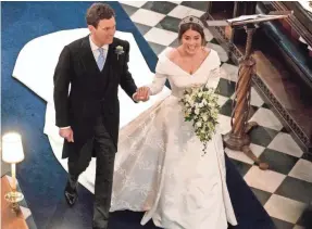  ?? OWEN HUMPHREYS/AFP/GETTY IMAGES ?? Princess Eugenie of York and Jack Brooksbank walk back down the aisle after their wedding at Windsor Castle on Friday.