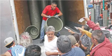  ??  ?? Ante la recomendac­ión de almacenar agua, capitalino­s abarrotaro­n los alrededore­s de La Merced para comprar recipiente­s donde guardarla.