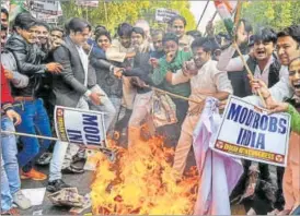  ?? AFP PHOTO ?? Congress supporters shout slogans as they burn an effigy of jewellery designer Nirav Modi, who is accused of defrauding Punjab National Bank, in New Delhi on Saturday.