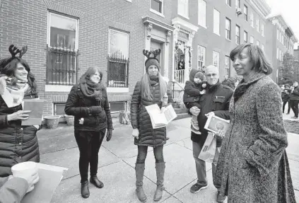  ?? AMY DAVIS/BALTIMORE SUN ?? Mayor Catherine E. Pugh, right, stops by Hollins Street on Sunday to chat with participan­ts during the 31st annual Union Square Holiday Cookie Tour. Next to the mayor are neighborho­od residents Bob Wiley with his son, Preston, and Rachel Zubek, center;...
