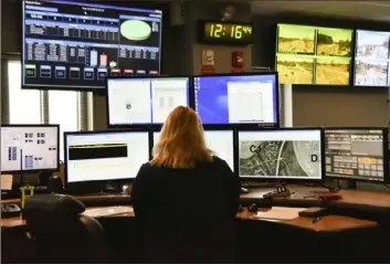  ?? Lisa Marie Pane/Associated Press ?? A dispatcher works March 15 at a desk station with a variety of screens used by those who take 911 emergency calls. The financial devastatio­n wrought by the pandemic has forced cuts that will reduce public services. In some areas, 911 calls are taking a longer time to be answered.