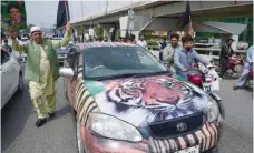  ?? — AFP ?? Supporters of Pakistan Muslim League-nawaz (PML-N) march during an election campaign rally in Rawalpindi on Sunday.