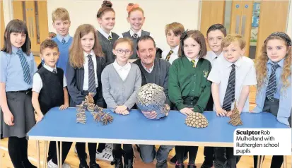  ??  ?? SculptorRo­b Mulholland with Rutherglen school pupils 73’s nature trail which has been made possible thanks to a £12,000 grant from Tesco’s Bags of Help initiative.