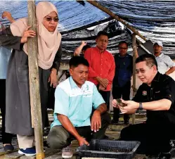  ?? - Bernama photo ?? Salahuddin Ayub (right) and wife Datin Fatimah Taha (second left) during a visit to a soft shell crab farm at Kampung Bambangan yesterday.