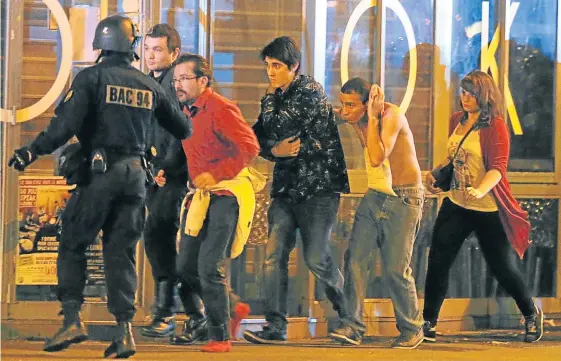  ?? Picture: REUTERS ?? FOLLOW US: French special forces evacuate people near the Bataclan concert hall in Paris, including an injured man