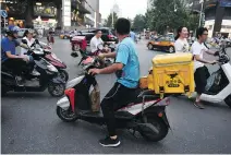  ?? GREG BAKER/AFP/GETTY IMAGES ?? Food delivery giant Meituan Dianping is turning to the public markets as it burns cash to fuel its growth.