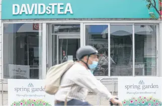  ?? TIM KROCHAK ■ THE CHRONICLE HERALD ?? A cyclist rides by the downtown Halifax location of David's Tea on Wednesday afternoon. The chain has filed for bankruptcy protection.