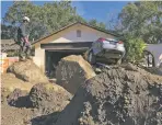  ?? MIKE ELIASON SANTA BARBARA COUNTY FIRE DEPARTMENT VIA AP ?? Capt. John Pepper, Fresno Fire Department, and Rescue Squad Leader RTF-5 searches homes Saturday off East Valley Road in Montecito, Calif.