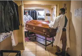  ?? Robert Gauthier Los Angeles Times ?? ATTENDANTS work at Continenta­l Funeral Home in East Los Angeles in August 2020. At the time, the home struggled to keep up with COVID-19 deaths.
