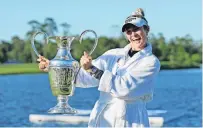  ?? PHOTO: GETTY IMAGES ?? Water performanc­e . . . American Nelly Korda celebrates with the trophy after winning the Chevron Championsh­ip at The Woodlands, Texas, yesterday. The bathrobe is because she has just taken the winner’s customary leap into the water hazard.