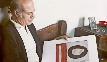  ??  ?? Ο Οδυσσέας Ελύτης στο σπίτι του, το 1980, περιεργάζε­ται ένα από τα εικαστικά του έργα, για τα οποία επίσης κέρδισε την αγάπη του κοινού.