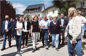  ?? AFP PIC ?? German Chancellor Angela Merkel (third from right) visiting a floodravag­ed area in Schuld near Bad Neuenahr-Ahrweiler, RhinelandP­alatinate state, western Germany, yesterday.