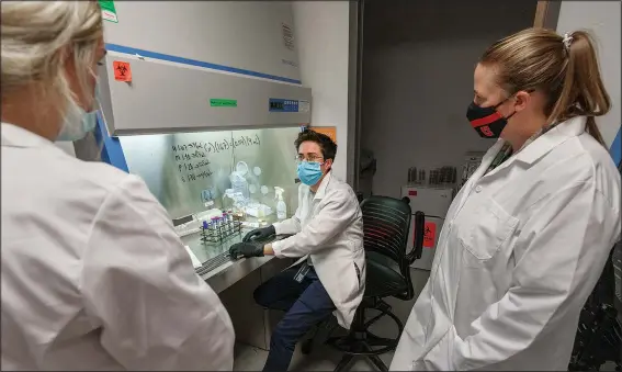  ?? (AP/The Salt Lake Tribune/Leah Hogsten) ?? First-year doctoral students Dakota Brady (left) and Madison McConnell (right) get informatio­n from second-year doctoral student Abby Scott on Oct. 26 as they isolate bacteria in the University of Utah’s College of Pharmacy lab.