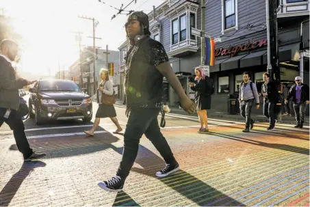  ?? Photos by Gabrielle Lurie / The Chronicle ?? Kat Blackburn, who started dressing as a girl around age 10 while growing up in Alaska, walks through the Castro district.