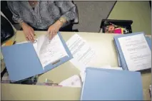  ??  ?? Deputy Clerk Vicky Griffith goes through old civil cases to send notices to attorneys in hopes of dismissals at the DeSoto County Courthouse.