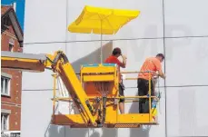  ?? FOTO: EVA-MARIE MIHAI ?? Sogar die Arbeiter an der Kubus-LED-Wand haben sich einen Sonnenschi­rm besorgt, um sich gegen Nilüfer zu schützen.