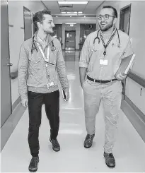  ?? SHARON MONTGOMERY • CAPE BRETON POST ?? Dalhousie University medical students Ryan Densmore of Fall River and Connor Bray of Sydney walk down a hallway at the Cape Breton Regional Hospital in Sydney in 2019. They were part of the medical school’s program that allows students to get hands-on training in a rural community for a full year.