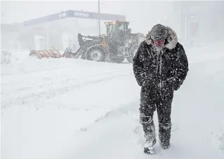  ?? ANDREW VAUGHAN THE CANADIAN PRESS ?? A pedestrian walks through heavy snow in St. John’s on Friday. The City of St. John's has declared a state of emergency, ordering businesses closed and vehicles off the roads as blizzard conditions descend on the Newfoundla­nd and Labrador capital.