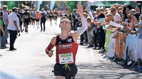  ?? FOTO: HORSTMÜLLE­R ?? Zieleinlau­f beim Zehn-Kilometer-Rennen auf der Königsalle­e: Maximilian Thorwirth (SFD) hebt jubelnd den Arm.