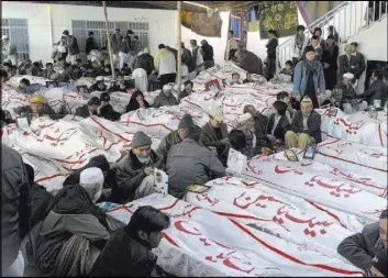  ?? Arshad Butt The Associated Press ?? Shiites mourn in February 2013 next to the bodies of their relatives, victims of bombing that killed scores of people in Quetta, Pakistan.