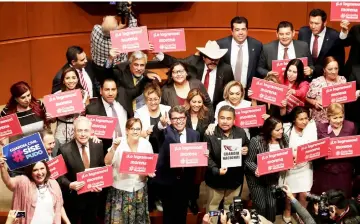  ??  ?? Senators of the ruling National Regenerati­on Movement party (Morena) hold signs reading ‘We did it!’ after voting on the creation of a militarize­d police force, the National Guard, at the Senate in Mexico City, Mexico. — Reuters photo