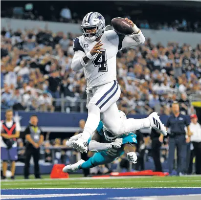  ?? RON JENKINS/ASSOCIATED PRESS ?? Cowboys quarterbac­k Dak Prescott gets past Miami Dolphins defensive back Walt Aikens and into the end zone for a touchdown during the second half in Arlington, Texas. Prescott added two touchdown passes in the win.