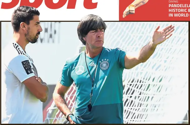  ??  ?? All ears: Germany coach Joachim Loew (right) giving instructio­ns to Sami Khedira during a training session at the Rungghof training centre in northern Italy on Tuesday.