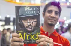  ?? — AFP photo ?? A Pakistani cricket fan holds Pakistan’s cricketer Shahid Afridi’s autobiogra­phy as he came for a press conference to present the book in Karachi on May 4, 2019.