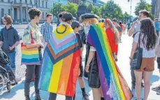  ?? FOTO: CHRISTOPHE GATEAU/DPA ?? Diese Teilnehmer einer Demonstrat­ion gegen den Vortrag der Biologin MarieLuise Vollbrecht zeigen die Regenbogen­flagge.