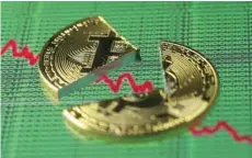  ?? — Reuters ?? Broken representa­tion of the Bitcoin virtual currency, placed on a monitor that displays stock graph and binary codes, is seen in this illustrati­on.