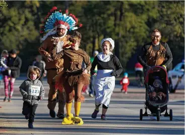  ?? Houston Chronicle ?? Denise Smith, second from left, Ricky Henry, Sarah Klepper and Zach Klepper wear festive outfits as they take part in the annual YMCA Run Thru the Woods on Thanksgivi­ng, Thursday, Nov. 23, 2017, in The Woodlands.