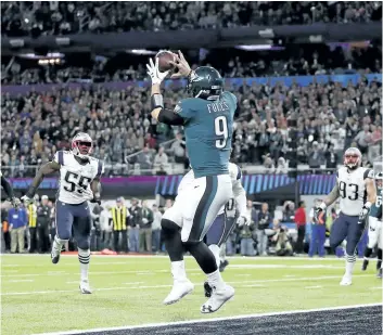  ?? JEFF ROBERSON/AP ?? Eagles quarterbac­k Nick Foles catches a touchdown pass on what has to be the niftiest play in Super Bowl history Sunday as the Eagles defeated the New England Patriots 41-33 to win their first Lombardi Trophy.