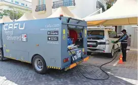  ??  ?? Ugandan Mullika Indy, an employee of CAFU, the first fuel delivery service in the region, service, refills a car using a mini tanker outside a client’s house in Dubai, in the United Arab Emirates.