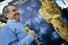  ?? Paul Beaty/The Associated Press ?? Tom Sherak waits with an Oscar before boarding “Oscar One” heading to Los Angeles for the Academy Awards ceremony, at O’Hare Internatio­nal Airport in Chicago on Feb. 9, 2012.