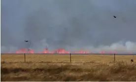  ?? Photograph: Leah Millis/Reuters ?? A wildfire can be seen, slightly through heat waves, after it was whipped up by high winds in Pampa, Texas, on Saturday.