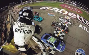  ?? ALEX SLITZ/GETTY IMAGES ?? Daniel Suarez (99) crosses the finish line ahead of Kyle Busch (8) and Ryan Blaney (12) to win the Ambetter Health 400 on Sunday at Atlanta Motor Speedway.