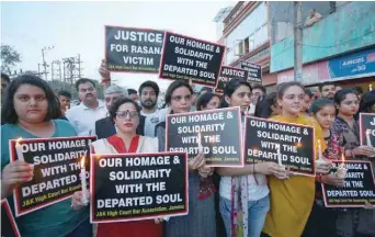  ??  ?? People hold candles and placards during a vigil, organised by the members of the Jammu and Kashmir High Court Bar Associatio­n, to show solidarity with the victim and demand a Central Bureau of Investigat­ion (CBI) probe into the rape and murder of an...