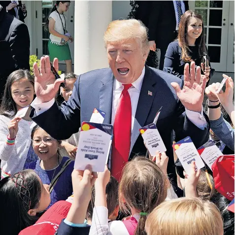  ??  ?? Donald Trump, the US president, signs autographs for children of staff and members of the press at the White House to mark ‘Take Our Daughters and Sons to Work Day’ yesterday. Sarah Huckabee Sanders, the White House press secretary, used the annual...