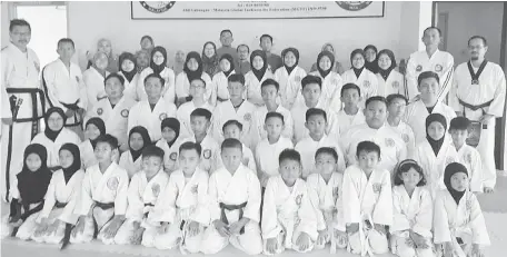  ??  ?? PELATIH: Abang Ahmad Zaini (berdiri, dua kanan) dan Ismaili (berdiri, kiri) bersama pelatih sebelum sesi ujian di Dojang, Bandar Baru Samariang.