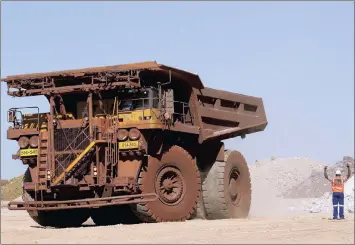  ?? PHOTO: REUTERS ?? A worker signals to a haul truck driver at Kumba Iron Ore, the world’s largest iron ore mine, in Kathu, Northern Cape Province, in this file photo. The company’s earnings were recently boosted by stronger prices.