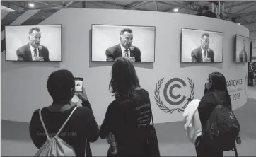  ?? The Associated Press ?? SKY THREAT: Visitors to the U.N. climate conference watch a speech by Arnold Schwarzene­gger, in Katowice, Poland, Monday. The COP24 UN Climate Change Conference is taking place in Katowice, Poland. Negotiator­s from around the world are meeting for talks on curbing climate change.