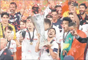  ?? — AFP photo ?? Sevilla captain Jesus Navas holds the trophy as Sevilla’s players celebrate after winning the UEFA Europa League final in Cologne, western Germany.