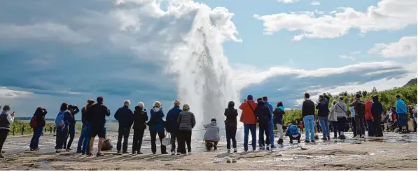  ?? Foto: Rebecca Krizak, dpa ?? Der Geysir Strokkur zieht viele Touristen an. Sie schauen gebannt zu, wenn der Geysir in die Höhe spritzt.