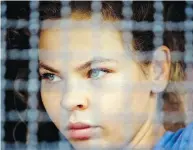  ?? GEMUNU AMARASINGH­E / THE ASSOCIATED PRESS ?? Anastasia Vashukevic­h sits in a police transport vehicle outside a detention centre in Thailand.