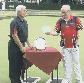  ??  ?? Mike Robertson (right) collects the Disability Bowls England Open Singles title.