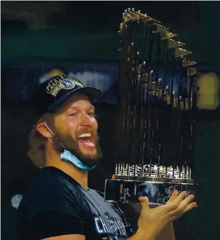  ?? RONALD MARTINEZ — GETTY IMAGES ?? Veteran pitcher Clayton Kershaw holds the Commission­er’s Trophy as the Dodgers celebrate their first World Series championsh­ip since 1988.