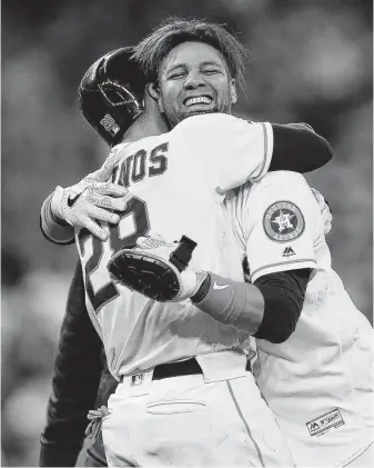  ?? Photos by Yi-Chin Lee / Staff photograph­er ?? Yuli Gurriel, right, receives a big hug from Astros teammate Robinson Chirinos on Saturday night after coming through with the winning hit in the 10th inning for the second straight game.