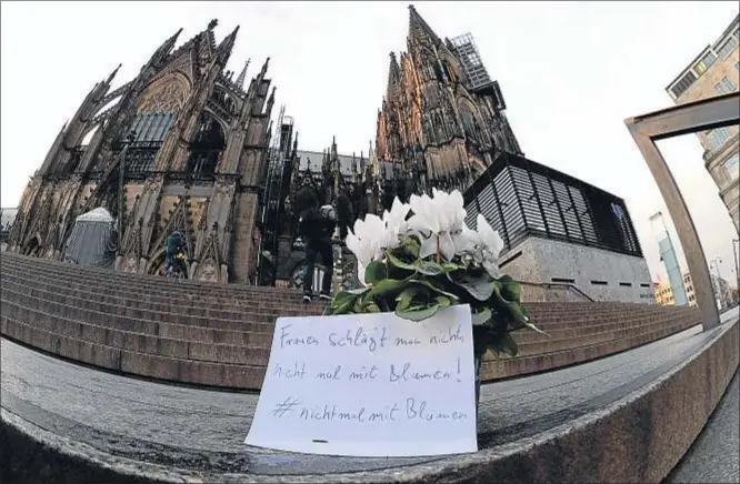  ?? ROBERTO PFEIL / AFP ?? En la escalinata de la catedral de Colonia, muy cerca del lugar de las agresiones, un papel dice: “A las mujeres no se las golpea, ni siquiera con flores”